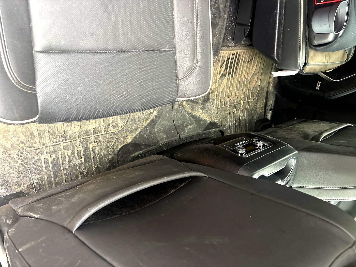 Before GMC Sierra rear interior detail North Bay — filthy rear floor mat